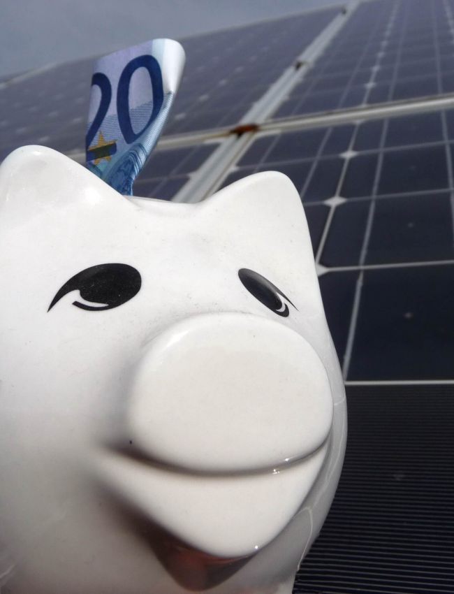Sparschwein mit 20 Euro Schein vor Solaranlage (oder Photovoltaikanlage)